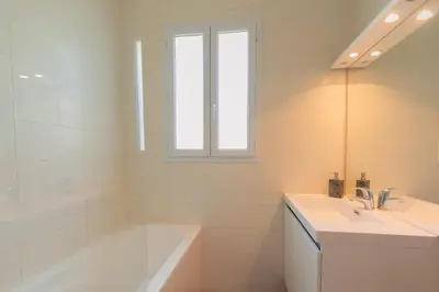 a white bathroom with a tub and a sink and a tubermott at Apartment near Croisette and Cannes festival in Le Cannet
