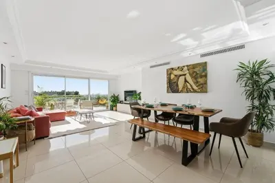 a living room with a table and a couch at Appartement Margot - Welkeys in Le Cannet