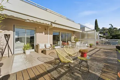 a house with a patio with chairs and a table at Appartement Margot - Welkeys in Le Cannet