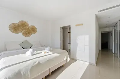 a white bedroom with a large bed with two hearts on the wall at Appartement Margot - Welkeys in Le Cannet