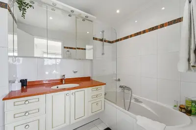 a bathroom with a sink and a tub and a shower at Appartement Margot - Welkeys in Le Cannet