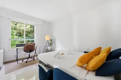 a room with a bed and a desk and a window at Appartement Margot - Welkeys in Le Cannet