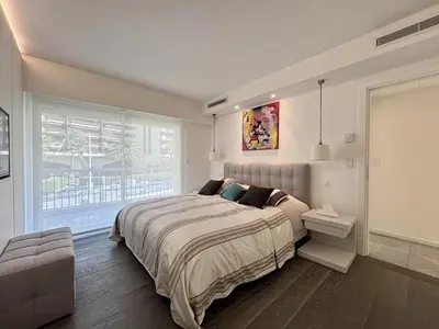 a bedroom with a large bed and a window at Superbe 2 pièces - Première ligne Croisette in Cannes