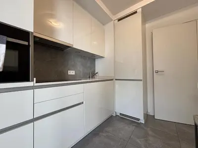 a kitchen with white cabinets and a sink and a door at Superbe 2 pièces - Première ligne Croisette in Cannes