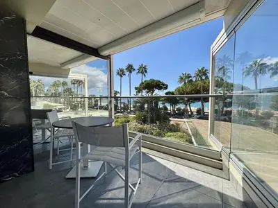 a balcony with a table and chairs and a view of the ocean at Superbe 2 pièces - Première ligne Croisette in Cannes