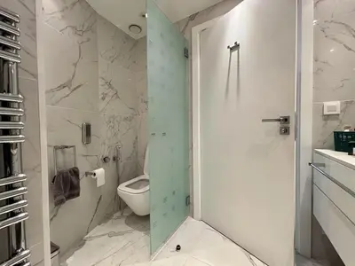 a bathroom with a toilet and a glass shower door at Superbe 2 pièces - Première ligne Croisette in Cannes