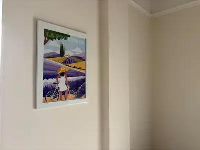 a framed poster of a woman on a bike on a wall at Appartement cosy - 4 personnes - Centre Cannes in Cannes