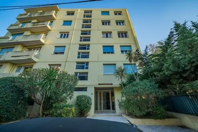 a tall yellow building with trees in front of it at COZYSTAY - Charmant 3 pièces en dernier étage in Cannes