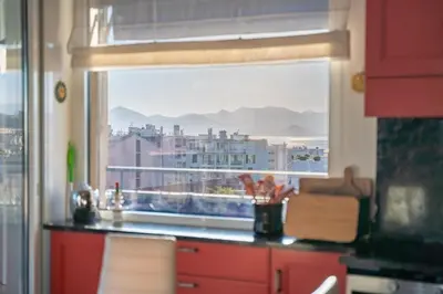 a kitchen with a window with a view of a city at COZYSTAY - Charmant 3 pièces en dernier étage in Cannes