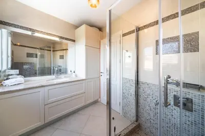 a bathroom with a walk in shower and a sink at COZYSTAY - Charmant 3 pièces en dernier étage in Cannes