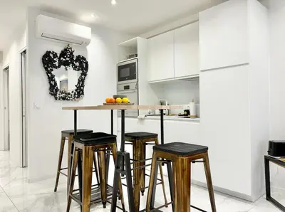 a kitchen with white cabinets and a counter with stools at Cannes one bedroom apartment - 20LM1 in Cannes