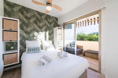 a bedroom with a large white bed with a large window at 1-Br Apartment Near the Beach and the Croisette Palm Beach in Cannes