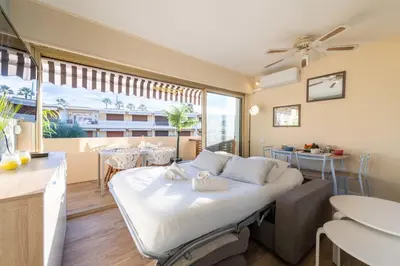 a bedroom with a bed and a dining room at 1-Br Apartment Near the Beach and the Croisette Palm Beach in Cannes