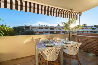 a dining table on a balcony with a view of a building at 1-Br Apartment Near the Beach and the Croisette Palm Beach in Cannes