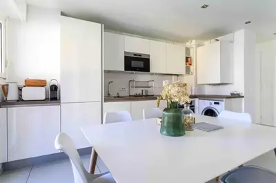 a white kitchen with a white table and white chairs at Cannes 2 bedrooms apartment & 2 bathrooms - 160A in Cannes