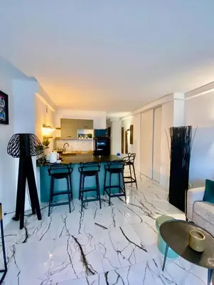 a living room with a table and chairs and a kitchen at Cannes 1 bedroom apartment - 20LM3 in Cannes