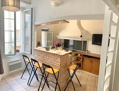 a kitchen with a bar with chairs and a counter at Cannes 1 bedroom apartment - 12RP1 in Cannes