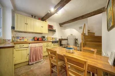 a kitchen with a wooden table and wooden cabinets at MIPIM Fisherman House Rooftop Terrace Walk to Palais Suquet in Cannes