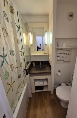 a bathroom with a sink and a toilet and a mirror at Studio cabine Cannes - Vue mer - Piscine - Parking in Cannes