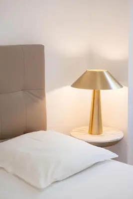 a gold lamp on a table next to a bed at Rez-de-Jardin à Cannes Centre - Luxe & Design in Cannes