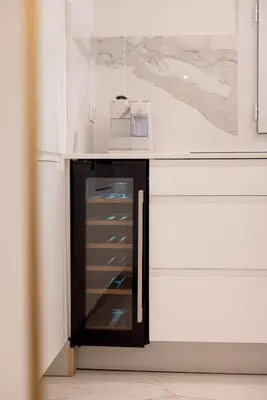 a kitchen with a cabinet with a glass door at Rez-de-Jardin à Cannes Centre - Luxe & Design in Cannes