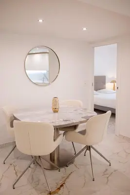 a dining room with a marble table and chairs and a mirror at Rez-de-Jardin à Cannes Centre - Luxe & Design in Cannes