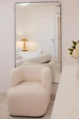 a white bedroom with a chair and a mirror at Rez-de-Jardin à Cannes Centre - Luxe & Design in Cannes