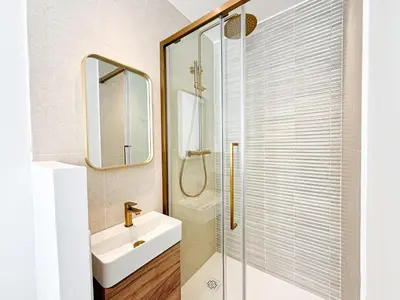 a bathroom with a sink and a glass shower at The Cosy Clémenceau in Cannes