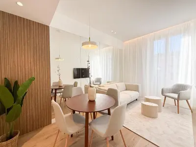a living room with a couch and a table and chairs at The Cosy Clémenceau in Cannes