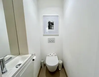 a white bathroom with a toilet and a sink at Atelier Meynadier in Cannes