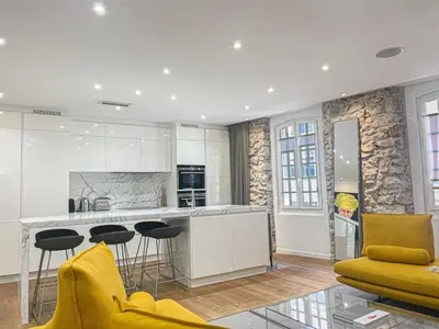 a kitchen and living room with yellow chairs and a counter at Atelier Meynadier in Cannes