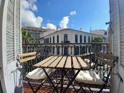 a picnic table on a balcony with a building at Lecerf in Cannes