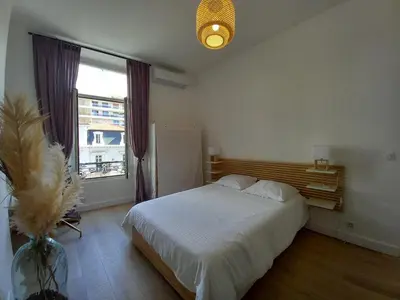 a bedroom with a white bed and a window at Lecerf in Cannes