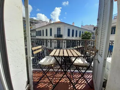 a table and chairs on a balcony with a building at Lecerf in Cannes