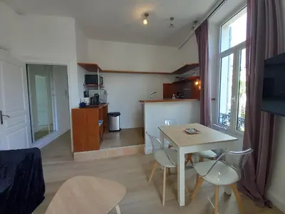a kitchen and living room with a table and chairs at Lecerf in Cannes