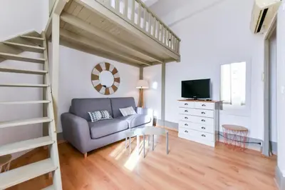 a living room with a couch and a staircase at Studio élégant pour 4 personnes, à quelques pas de la Croisette in Cannes
