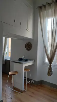 a kitchen with a counter and stools in a room at Studio élégant pour 4 personnes, à quelques pas de la Croisette in Cannes