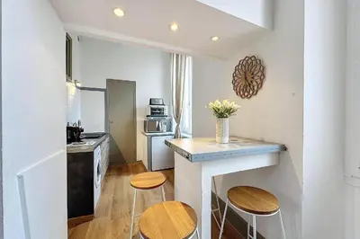 a kitchen with a counter and two stools in it at Studio élégant pour 4 personnes, à quelques pas de la Croisette in Cannes