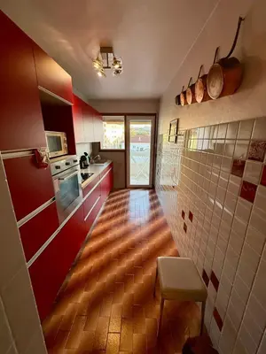 a kitchen with red walls and a wooden floor at Spacious 2-Bedroom Apartment with Terrace Prime Location in Cannes in Cannes