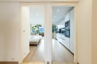 a kitchen and living room with white walls at 3-Br Crossing Apartment Palm Beach in Cannes