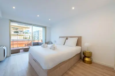 a bedroom with a large bed and a large window at 3-Br Crossing Apartment Palm Beach in Cannes