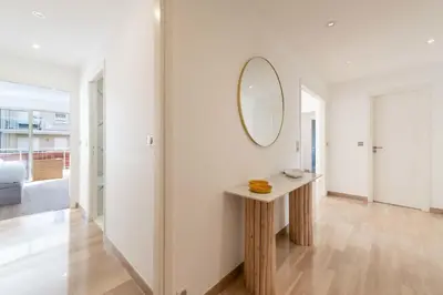 a hallway with a table and a mirror on the wall at 3-Br Crossing Apartment Palm Beach in Cannes
