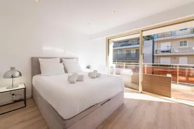 a bedroom with a large white bed and a large window at 3-Br Crossing Apartment Palm Beach in Cannes