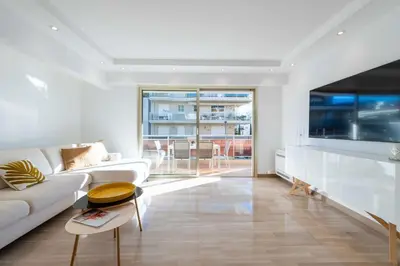 a white living room with a couch and a table at 3-Br Crossing Apartment Palm Beach in Cannes
