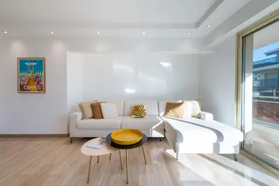 a living room with a white couch and a table at 3-Br Crossing Apartment Palm Beach in Cannes