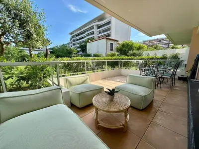 a balcony with couches and a table and chairs at Le Casta - Terrasse spacieuse - à 2 min des plages in Cannes