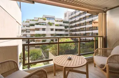 a balcony with a table and chairs and a large window at A C apt in the heart of Cannes—Croisette Beaches in Cannes