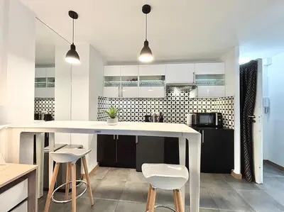 a kitchen with a large white counter and stools at Cannes 1 bedroom apartment - 57A2 in Cannes