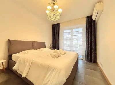 a bedroom with a bed with white sheets and a chandelier at Cannes 1 bedroom apartment - 57A2 in Cannes