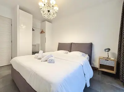 a bedroom with a large white bed with a chandelier at Cannes 1 bedroom apartment - 57A2 in Cannes